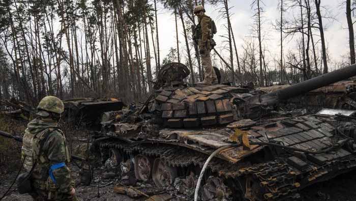 Tentara Ukraina berdiri di atas salah satu tank Rusia yang hancur di pinggiran Kiev