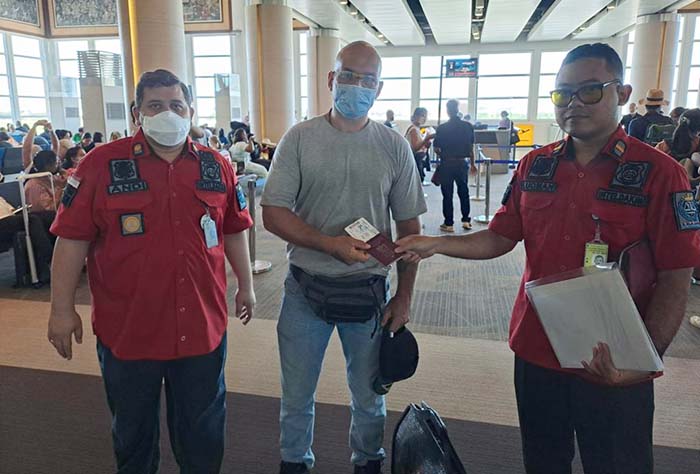 Petugas Imigrasi Singaraja mengawal WN Polandia saat dideportasi di Bandara Ngurah Rai Bali, Senin (27/6/2022). M-006