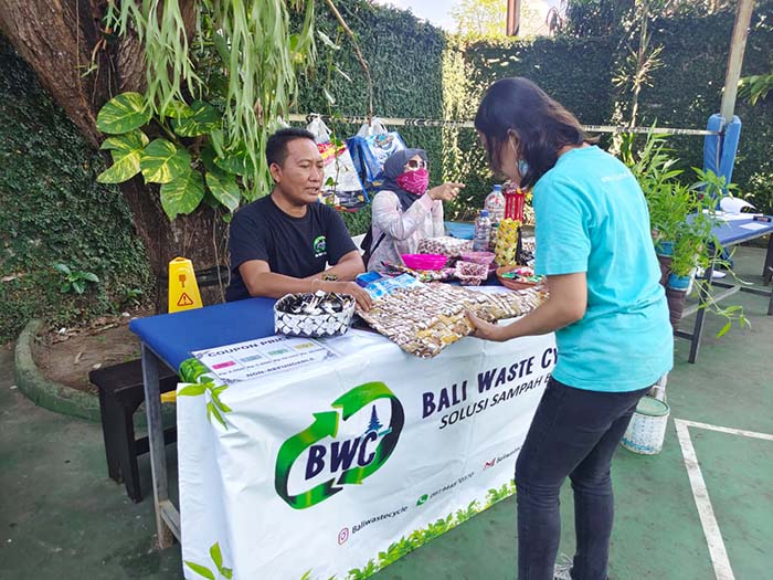 seorang pengunjung melihat kerajinan dari daur ulang sampah