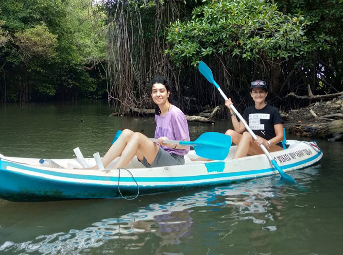 Wisatawan yang sedang melaksanakan tour mangrove dengan cano, sambil melakukan pembersihan