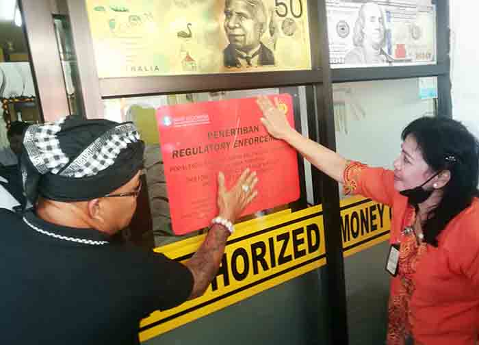 Petugas menutup money changer tak berizin di Kuta. (MENIT:008)