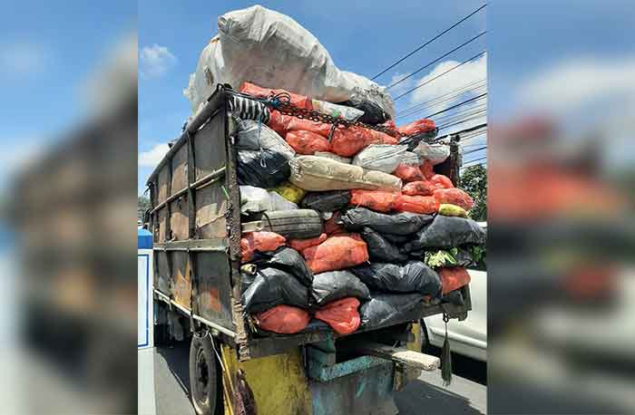 Kendaraan pengangkut sampah tanpa penutup melintasi Jalan Raya Dalung, Minggu (11/11/2022)