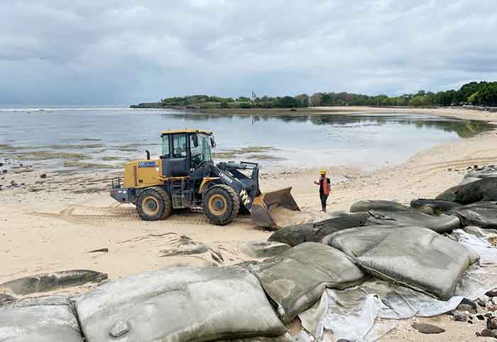 Alat berat diterjunkan untuk membersihkan geobag yang rusak di Pantai Selagan Nusa Dua.