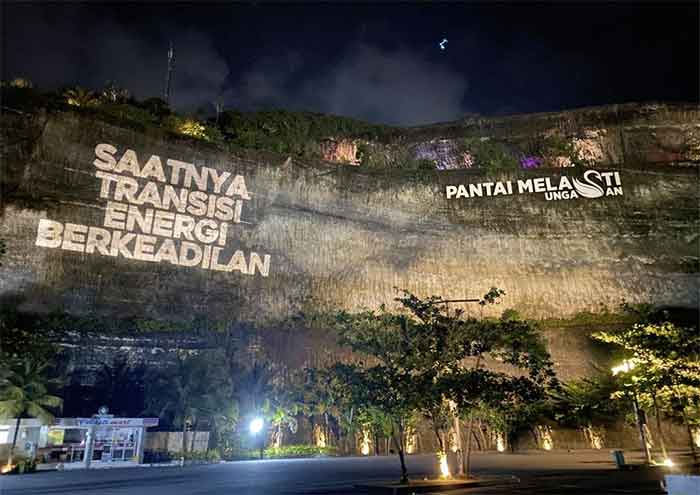 Greenpeace menggelar aksi damai kreatif dengan memproyeksikan pesan berbunyi “Saatnya Transisi Energi Berkeadilan” di Pantai Melasti, Bali, pada Senin petang, 14 November 2022.