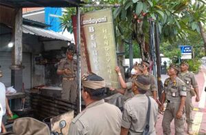 Petugas sedang menurunkan baliho Puan Maharani di sepanjang jalur delegasi KTT G-20.