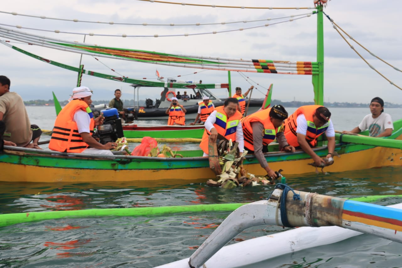 Bupati Jembrana I Nengah Tamba menghaturkan Banten Pakelem ke tengah laut, Minggu (25/12) di Desa Pengambengan. (Foto: Menitini/M-011)