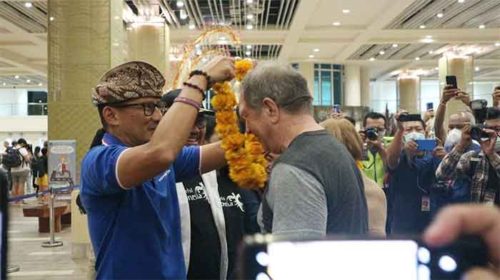 Menteri Pariwisata dan Ekonomi Kreatif/Kepala Badan Pariwisata dan Ekonomi Kreatif (Menparekraf/Kabaparekraf) Sandiaga Salahuddin Uno menyambut wisatawan pertama yang tiba di Bandara Ngurah Rai dengan mengalungi bunga.