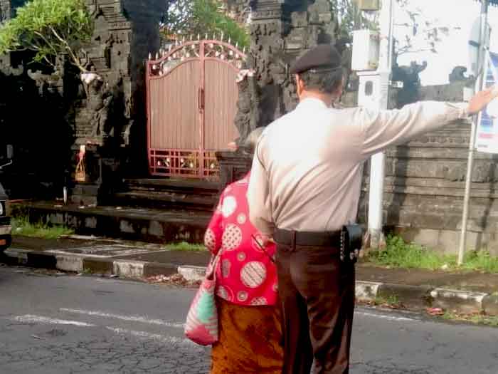 Ipda Made Nuarta membantu lansia menyeberang, Rabu (01/02/23) pukul 07.00 wita