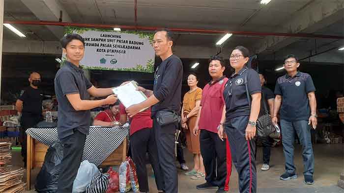 Kepala Unit Pasar Badung A A Ngurah Wijaya Kusuma dan Direktur Marketing Bali Waste Cycle (BWC) menunjukkan surat kesepakatan kerja sama bank sampah di Pasar Badung. (Foto: M-011)