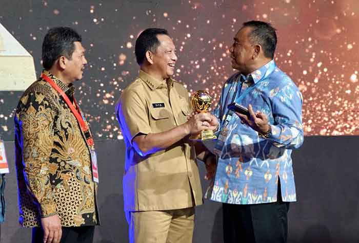 Tito-Karnavian-saat-menyerahkan-penghargaan-UHC-Award-2023--kepada-Bupati-Jembrana,-I-Nengah-Tamba-di-Balai-Sudirman,-Jakarta,-Selasa (14/3)