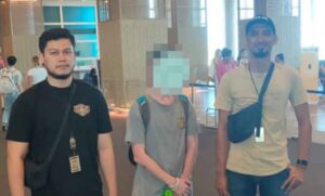 Warga negara Amerika Serikat JWH dikawal petugas. (foto: istimewa)