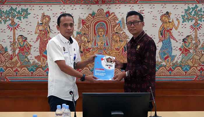 Ketua PWI Bali IGMB Dwikora dan Kepala Kantor Distrik Navigasi Kelas II Benoa Azhar Karim saling bertukar cindera mata