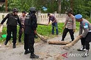 Polisi bersama Warga Masyarakat Wakal membuka barikade jalan raya. (Foto: Antara)