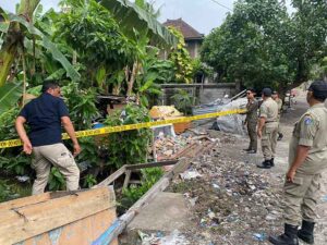 Satuan Polisi Pamong Praja saat memasang garis Satpol PP line di Jalan Muding Sari 100x Lingkungan Jambe, Kelurahan Kerobokan Kaja, Kecamatan Kuta Utara.