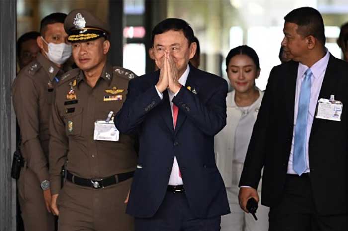Mantan Perdana Menteri Thailand Thaksin Shinawatra disambut pihak berwenang saat tiba di Bangkok. (Foto: AFP)