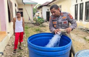 Waka-Polres-Seram-Bagian-Timur-(SBT),-Kompol-Muhammad-Musaat-sedang-membantu-menyuplai-air-bersih-kepada-warga-Bula
