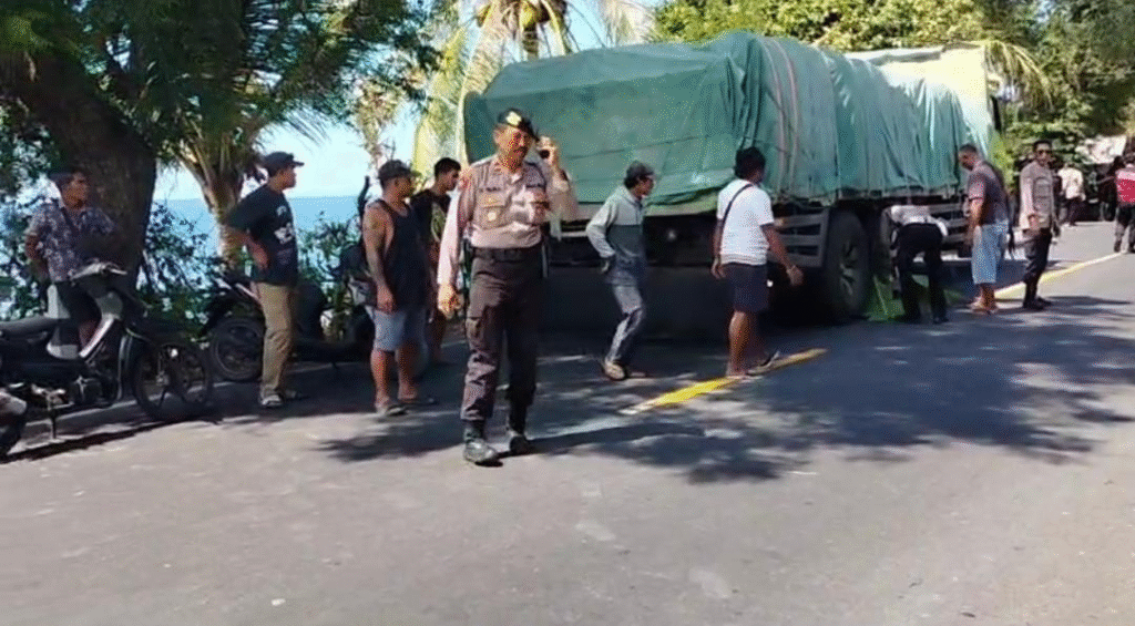 Petugas kepolisian bersama warga berada di lokasi kecelakaan di jalur pantura Singaraja–Karangasem, Desa Bukit, Kubutambahan, Buleleng, Kamis (28/8).