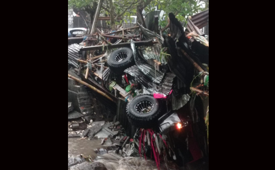mobil terseret arus banjir dan menumpuk bersama material bangunan di kawasan Ubung, Denpasar, Rabu (10/9). Hujan deras menyebabkan luapan sungai hingga menghanyutkan kendaraan dan merendam rumah warga.