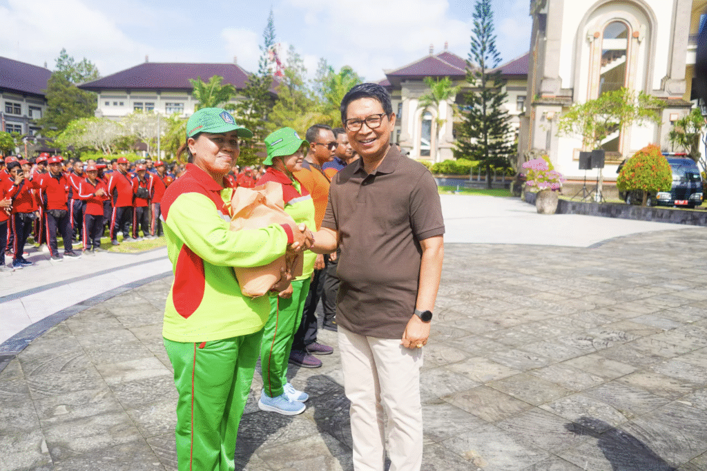 Bupati Badung Adi Arnawa meyerahkan sembako kepada pekerja lapangan yang bekerja akstra saat banjir di Badung