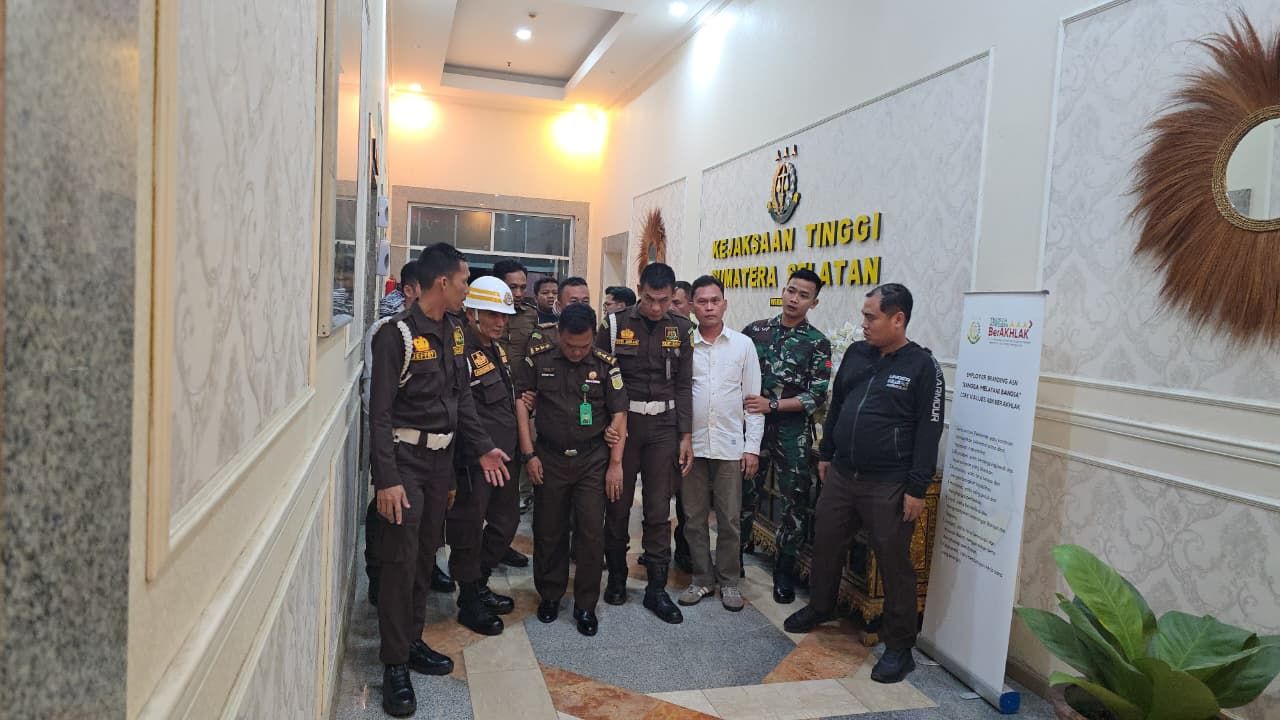 Petugas Kejaksaan Negeri Ogan Komering Ilir menggiring pria berinisial BA yang diduga jaksa gadungan, usai diamankan di sebuah rumah makan di Kayu Agung, Senin (6/10/2025).