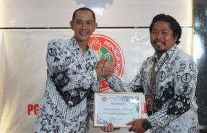 Wakil Bupati Klungkung sekaligus Ketua PGRI Klungkung, Tjokorda Gde Surya Putra, menyerahkan piagam penghargaan kepada salah satu guru berprestasi pada peringatan HUT ke-80 PGRI di SMAN 2 Semarapura.