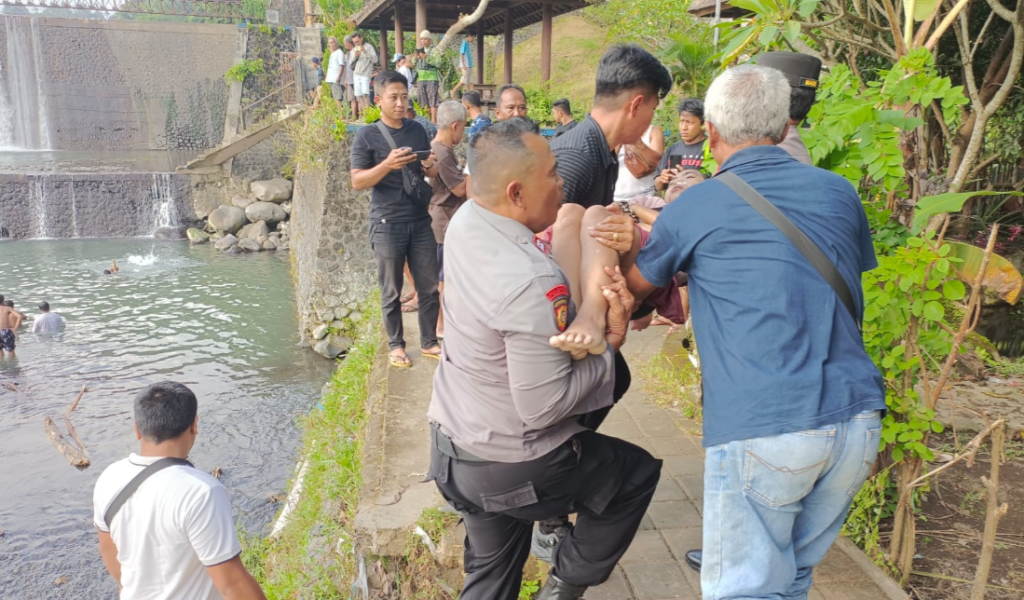 Petugas kepolisian bersama warga mengevakuasi korban tenggelam dari kawasan Sungai Unda, Klungkung, Minggu (21/12/2025)