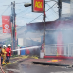 Petugas pemadam kebakaran berupaya memadamkan api yang melahap outlet ACK Bualu di Jalan Kurusetra, Kelurahan Benoa, Kuta Selatan, Selasa (20/1/2026).