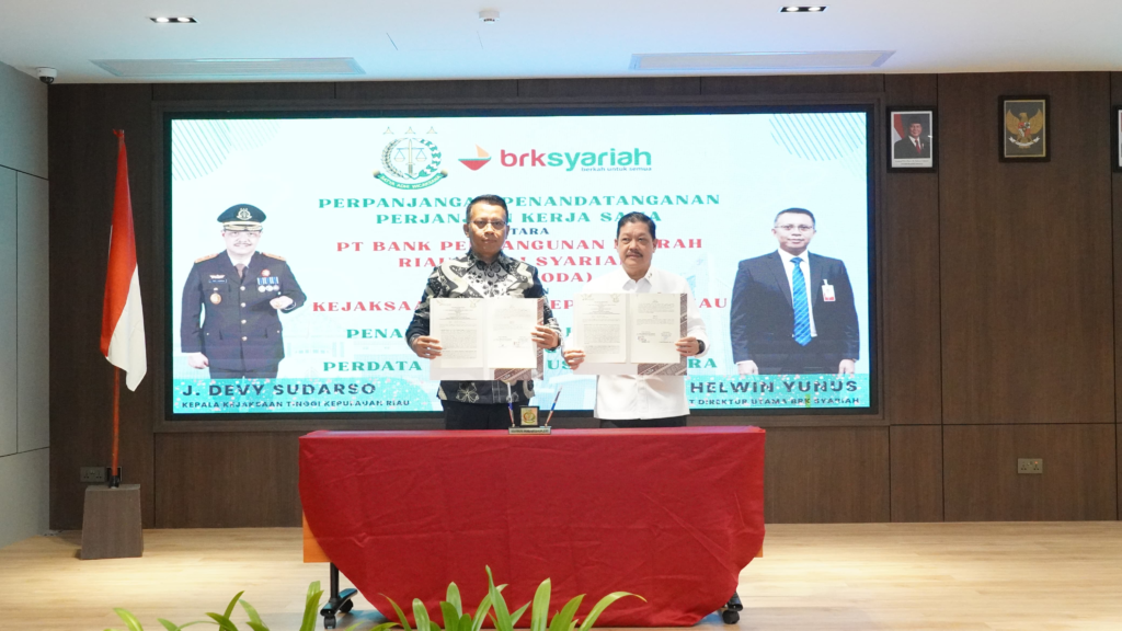 Kepala Kejaksaan Tinggi Kepulauan Riau J. Devy Sudarso dan Plt Direktur Utama BRK Syariah (Perseroda) Helwin Yunus menunjukkan dokumen Perjanjian Kerja Sama usai penandatanganan kerja sama penanganan masalah hukum bidang perdata dan tata usaha negara di Batam, Senin (26/1/2026).