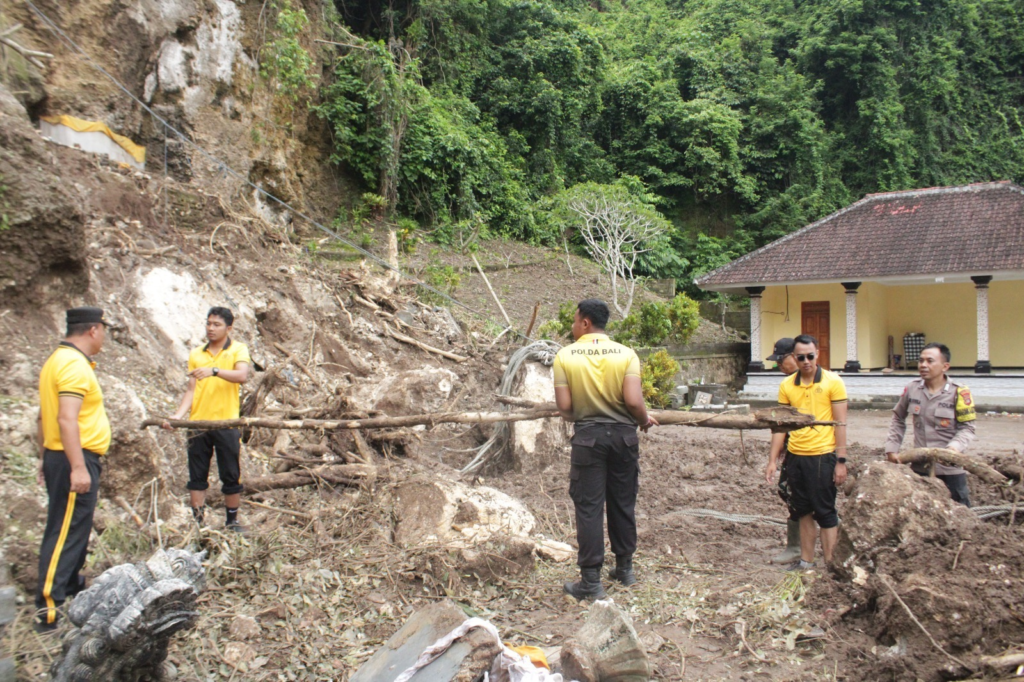 Petugas kepolisian bersama TNI dan warga melakukan pembersihan material longsor di kawasan Pura Ulun Danu Penida, Desa Sakti, Kecamatan Nusa Penida, Klungkung, Selasa (27/1/2026).