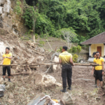Petugas kepolisian bersama TNI dan warga melakukan pembersihan material longsor di kawasan Pura Ulun Danu Penida, Desa Sakti, Kecamatan Nusa Penida, Klungkung, Selasa (27/1/2026).