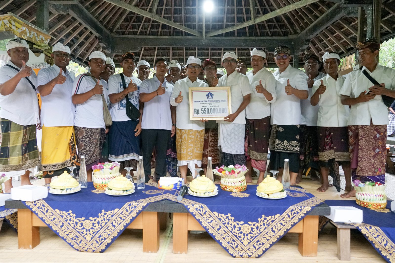 Bupati Adi Arnawa saat menyerahkan bantuan pemulihan dampak bencana Pura Taman Beji Magendra, Desa Adat Tegal Darmasaba, Desa Darmasaba, Kecamatan Abiansemal, Rabu (22/4).