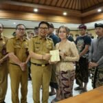 Bupati Adi Arnawa saat menyerahkan buku rekening tabungan kepada 26 Sekaa dan Komunitas Seni yang akan menjadi Duta Kabupaten Badung pada PKB XLVIII Tahun 2026, di Puspem Badung, Senin (13/4).