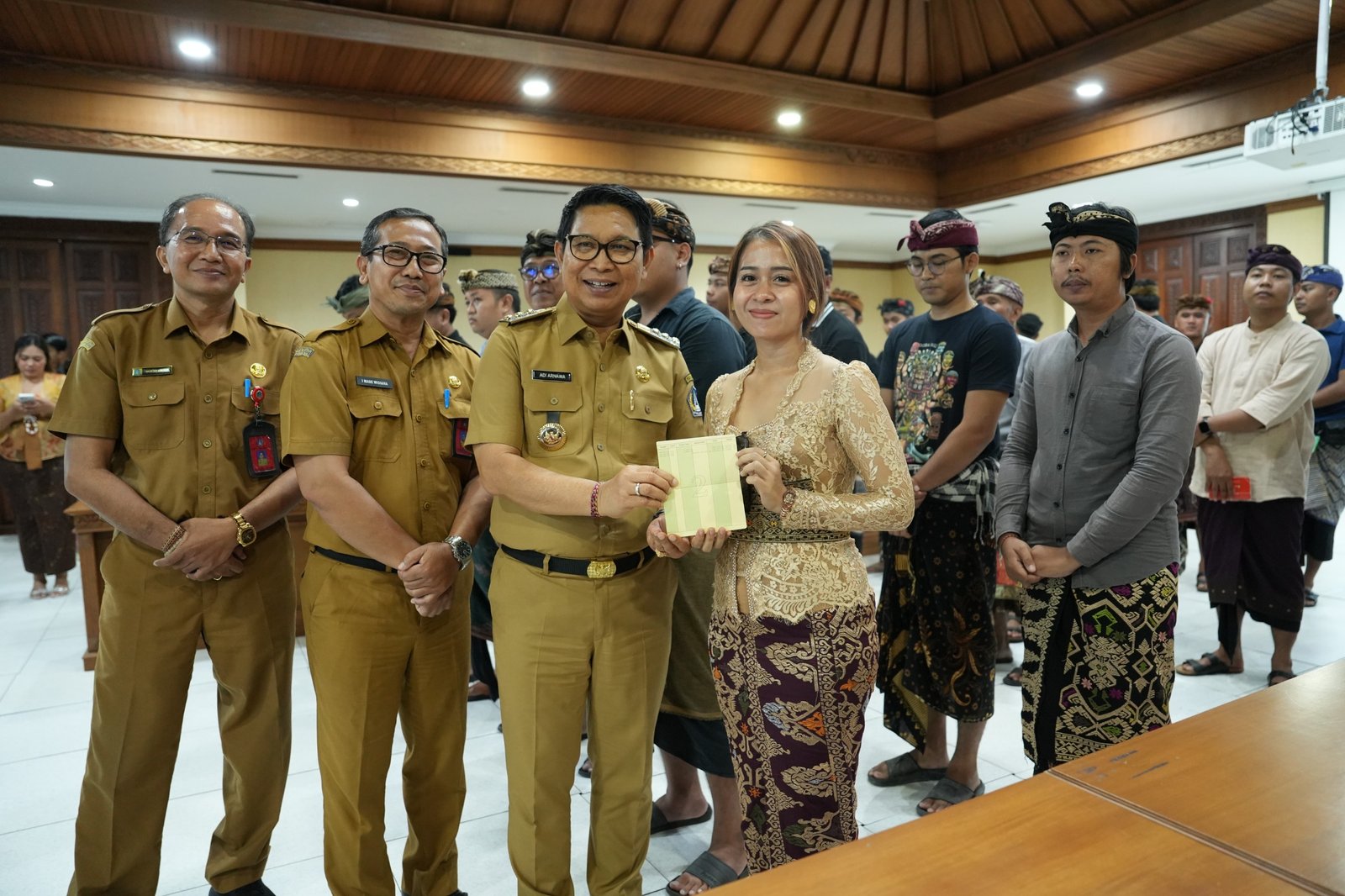 Bupati Adi Arnawa saat menyerahkan buku rekening tabungan kepada 26 Sekaa dan Komunitas Seni yang akan menjadi Duta Kabupaten Badung pada PKB XLVIII Tahun 2026, di Puspem Badung, Senin (13/4).