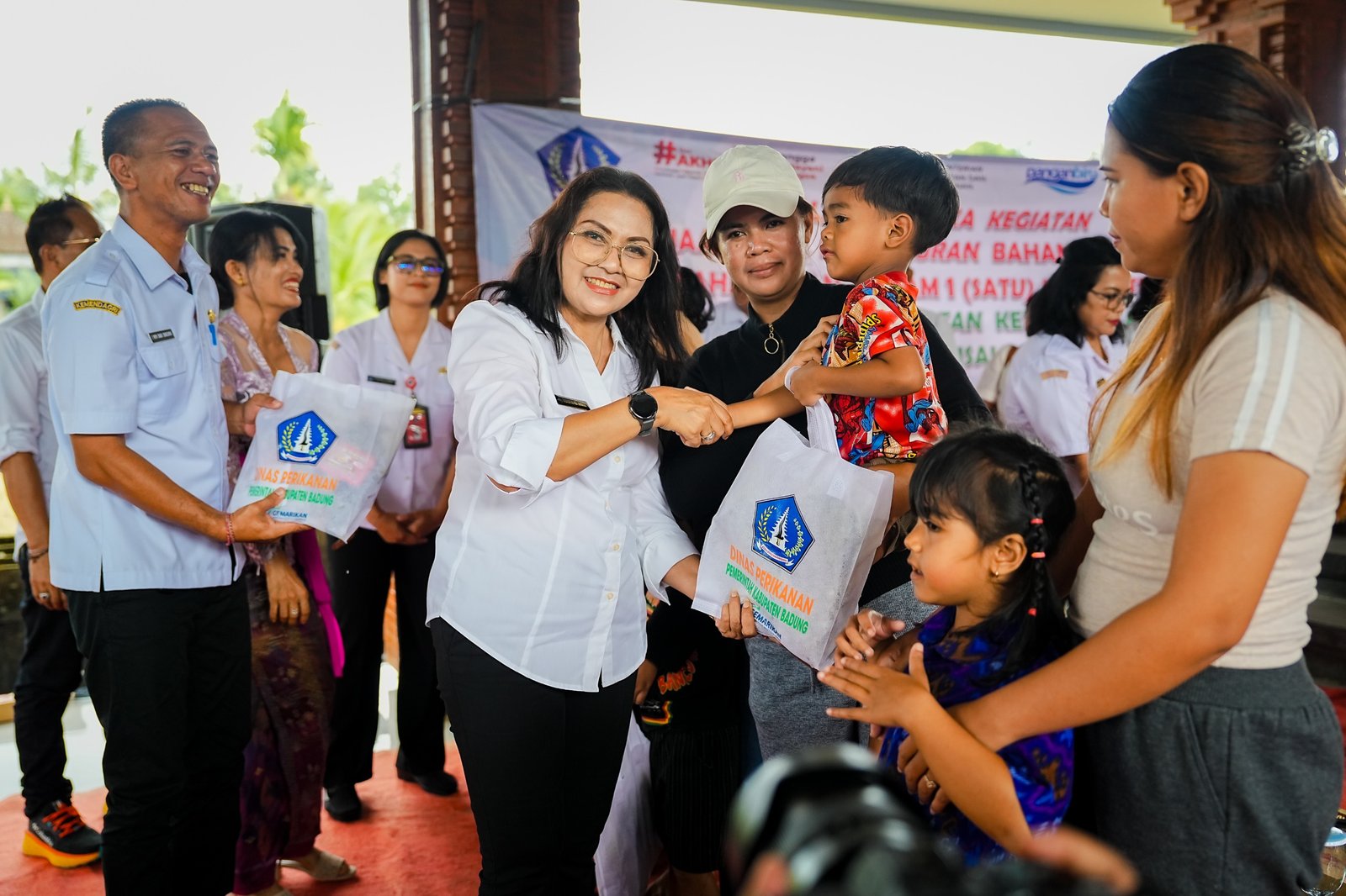 Ketua TP PKK Badung, Nyonya Rasniathi Adi Arnawa, menghadiri kegiatan penyaluran paket olahan ikan di Balai Banjar Buangga, Desa Getasan, Kecamatan Petang, Badung, pada Rabu (13/5).