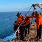 Tim SAR gabungan berhasil mengevakuasi dua orang yang terjebak air pasang di bawah tebing kawasan Uluwatu, Desa Pecatu, Kuta Selatan, Minggu (28/6/2026) pagi.