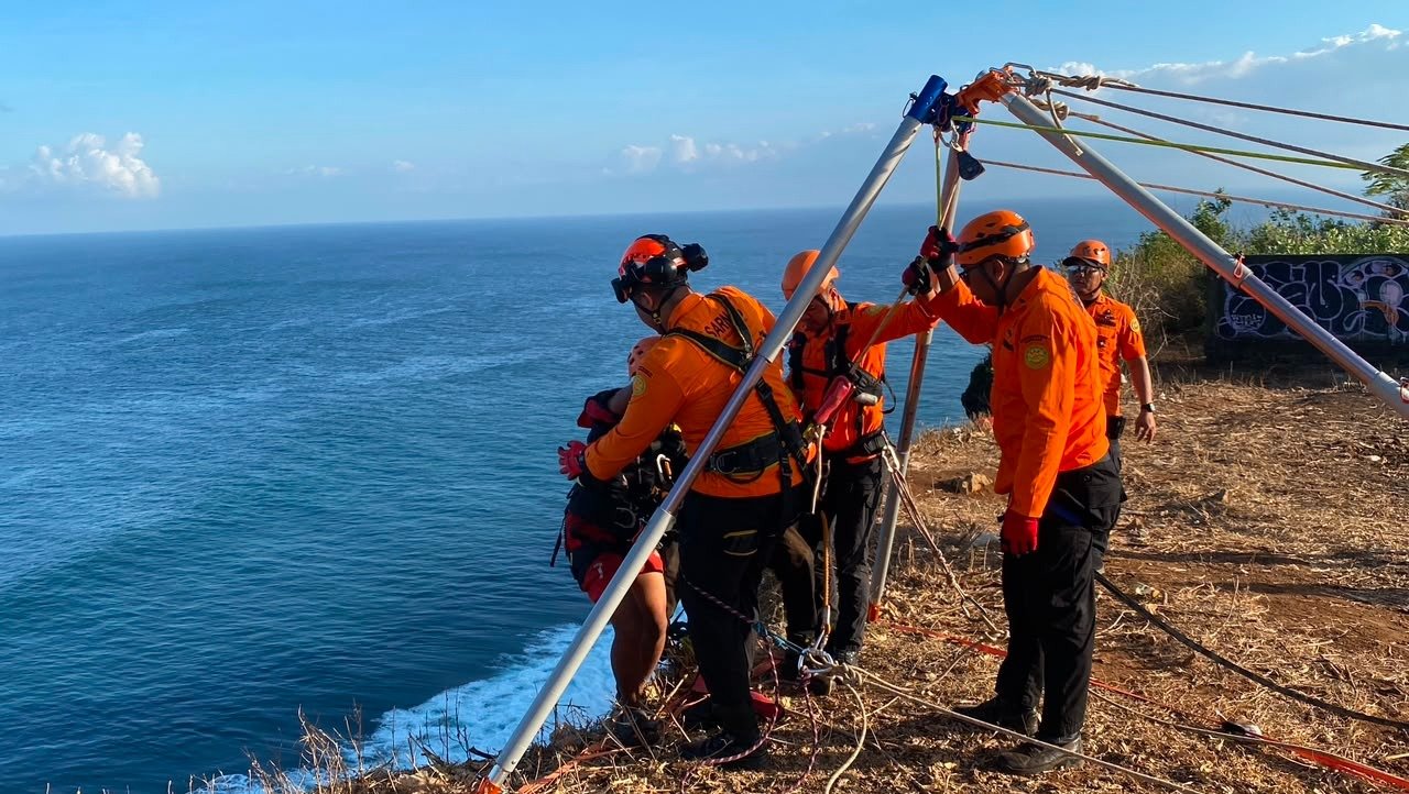 Tim SAR gabungan berhasil mengevakuasi dua orang yang terjebak air pasang di bawah tebing kawasan Uluwatu, Desa Pecatu, Kuta Selatan, Minggu (28/6/2026) pagi.