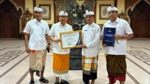Bupati Wayan Adi Arnawa saat menyerahkan Piagam Penghargaan kepada Kadis Sosial Badung I Gde Eka Sudarwitha di Puspem Badung, Selasa (14/7)